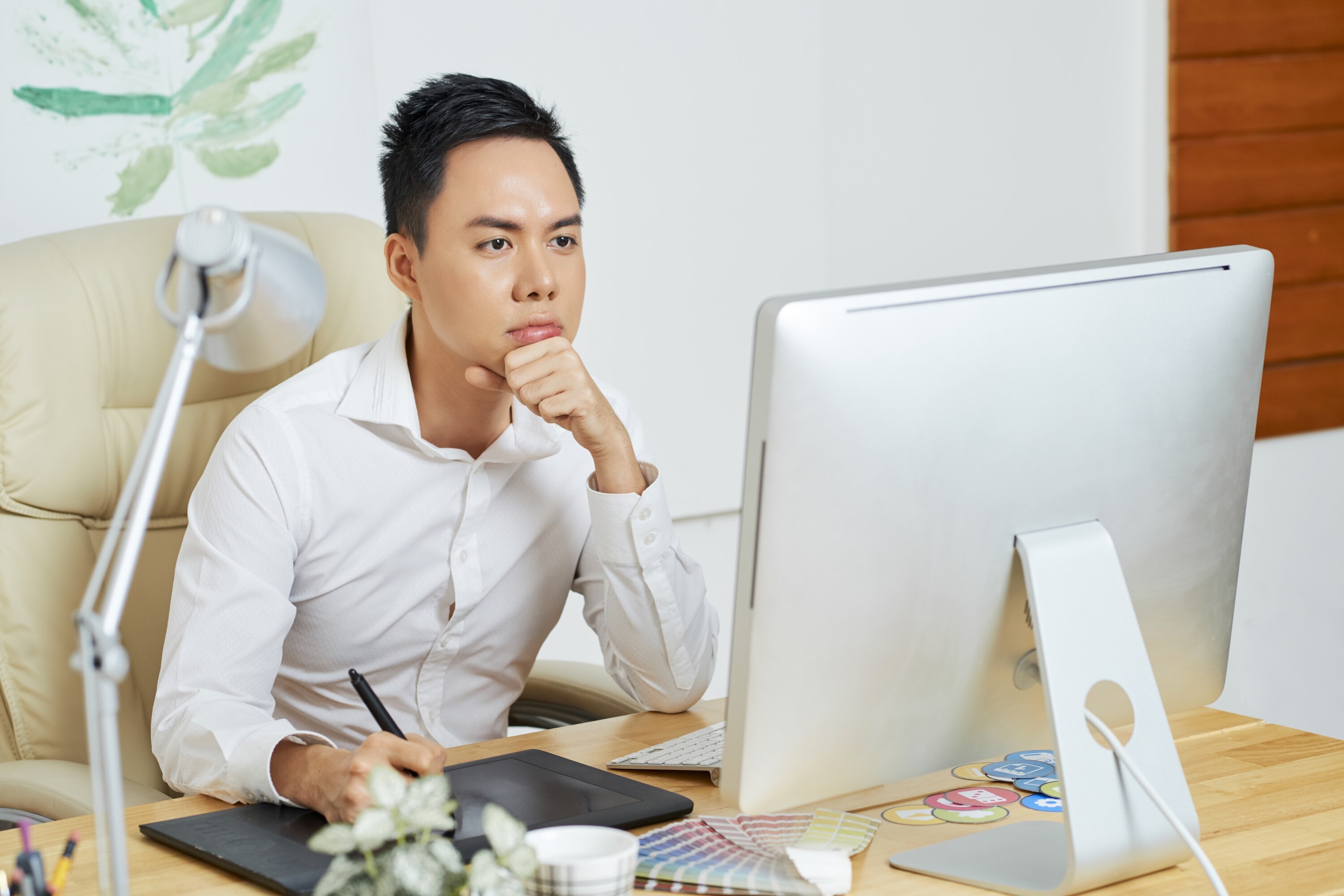 Graphic Designer concentrating at work looking at a computer screen.