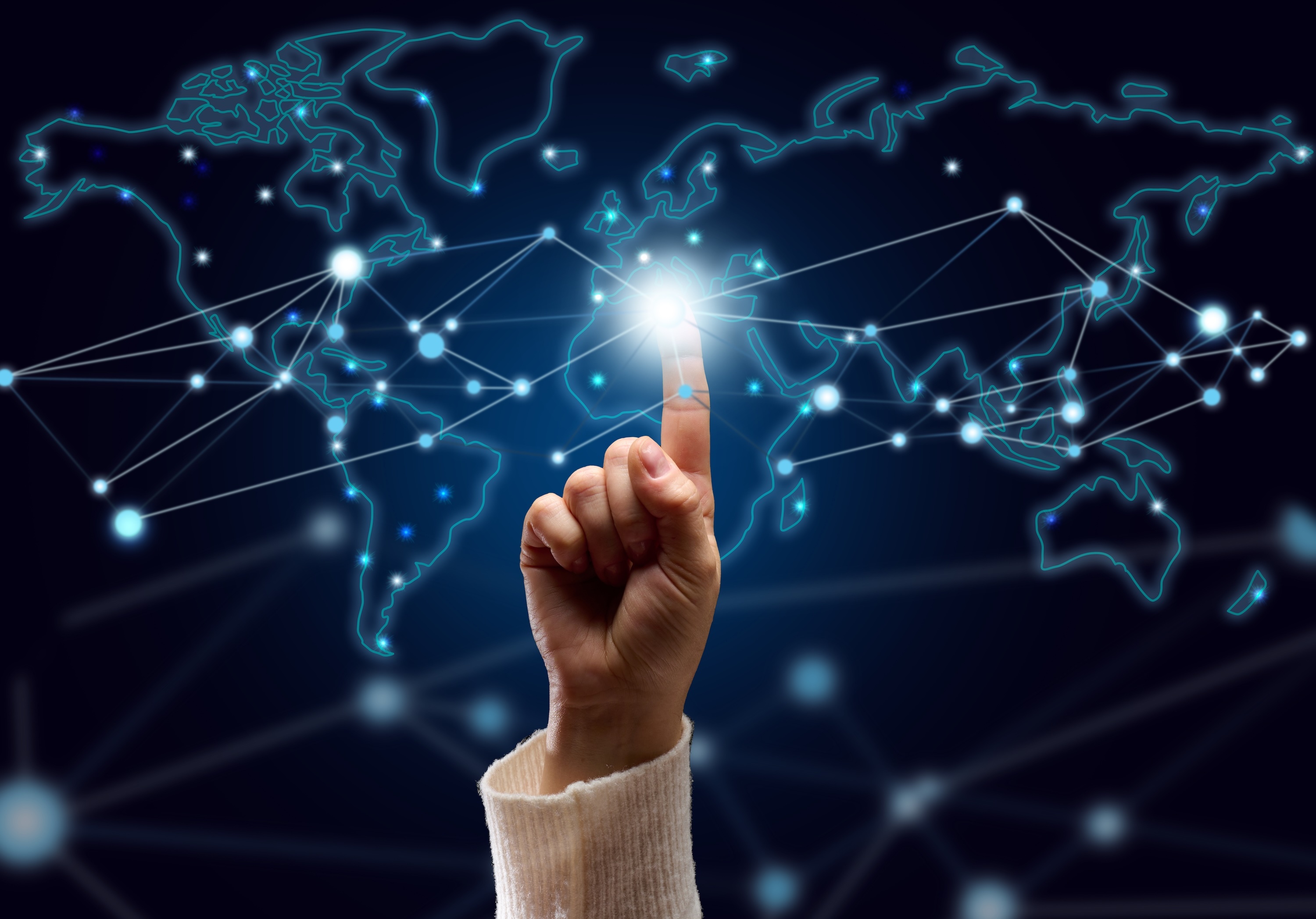 Hand touches holographic map of the world